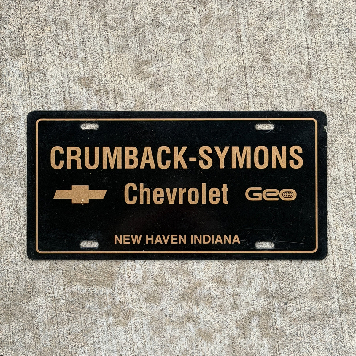 Photo of a 1990 Era New Haven Indiana Booster License Plate Auto Tag Garage Decor Vintage Crumback Symons Chevy Plastic with original patina