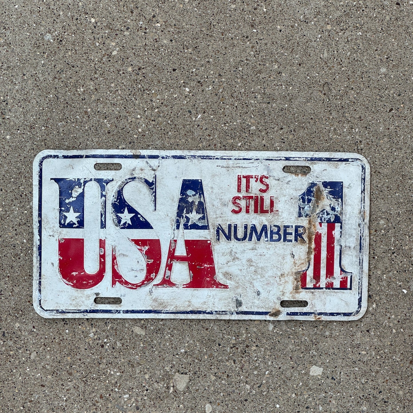 Photo of a 1990 Era Unnamed record Booster License Plate Auto Tag Garage Decor Vintage US America American Flag USA NUMBER 1