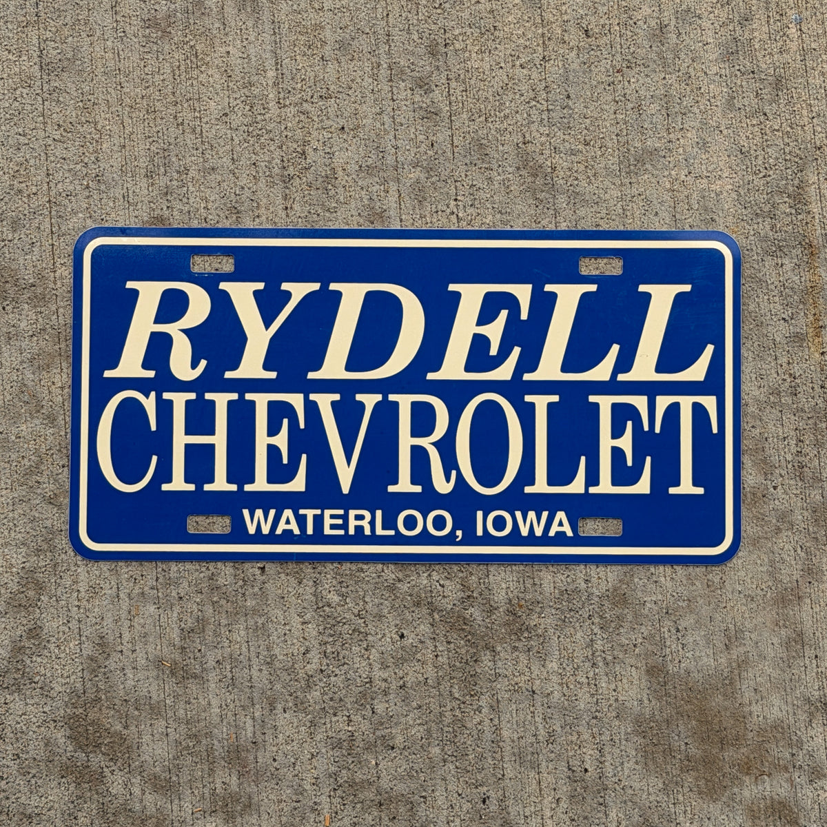 Photo of a 1990 Era Waterloo Iowa Booster License Plate Auto Tag Garage Decor Vintage Rydell Chevy Plastic with original patina
