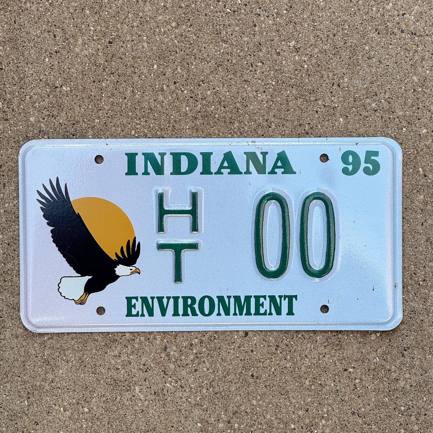 Photo of a 1994 1995 Indiana Graphic Sample License Plate Auto Tag Garage Decor Vintage Environment Bald Eagle HT 00 with original patina