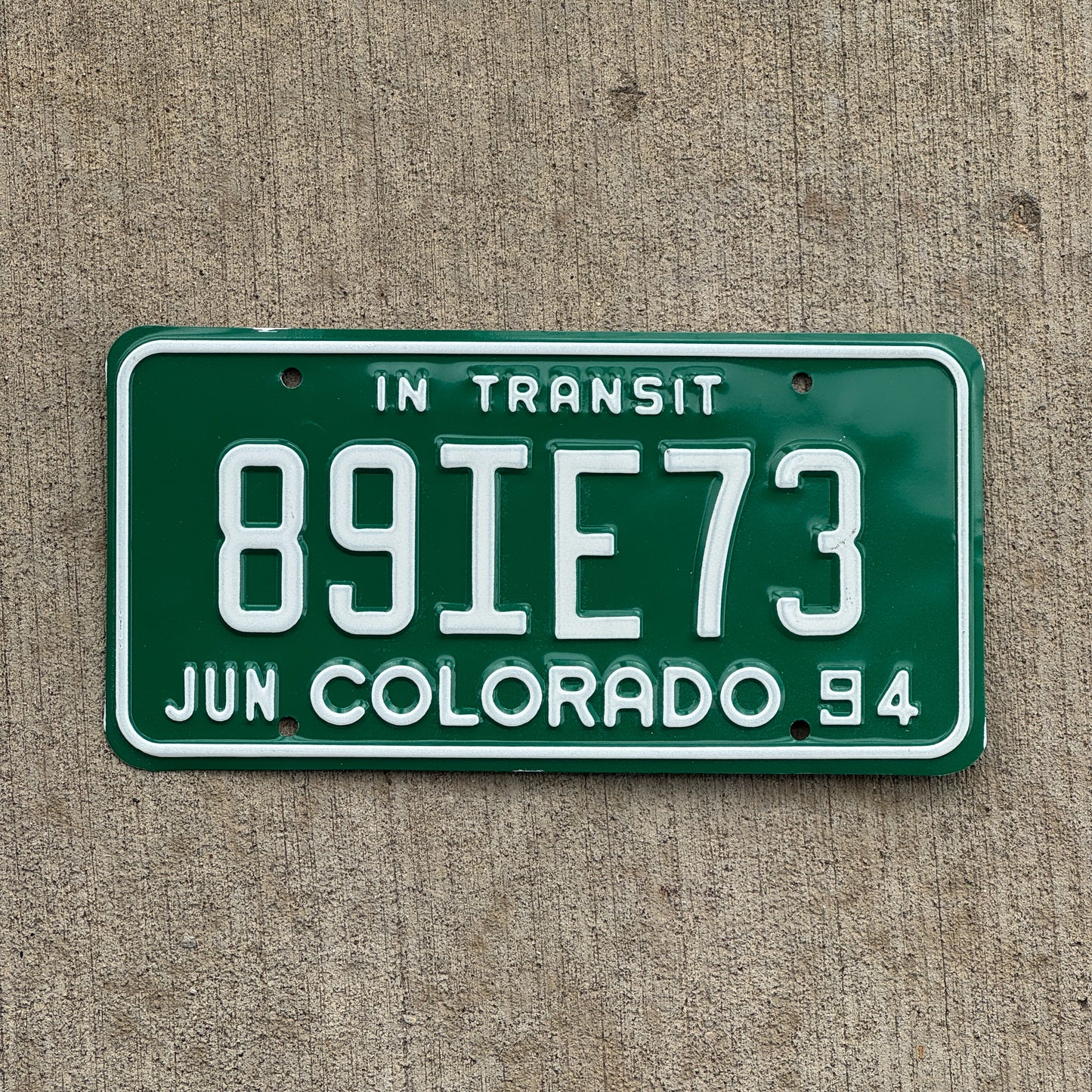 Photo of a 1994 Colorado In Transit Dealer License Plate Auto Tag Garage Decor Vintage 89 IE 73 with original patina
