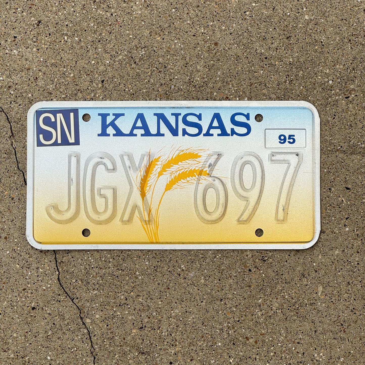 Photo of a 1995 Kansas Error License Plate Auto Tag Garage Decor Vintage Misprint JGX 697