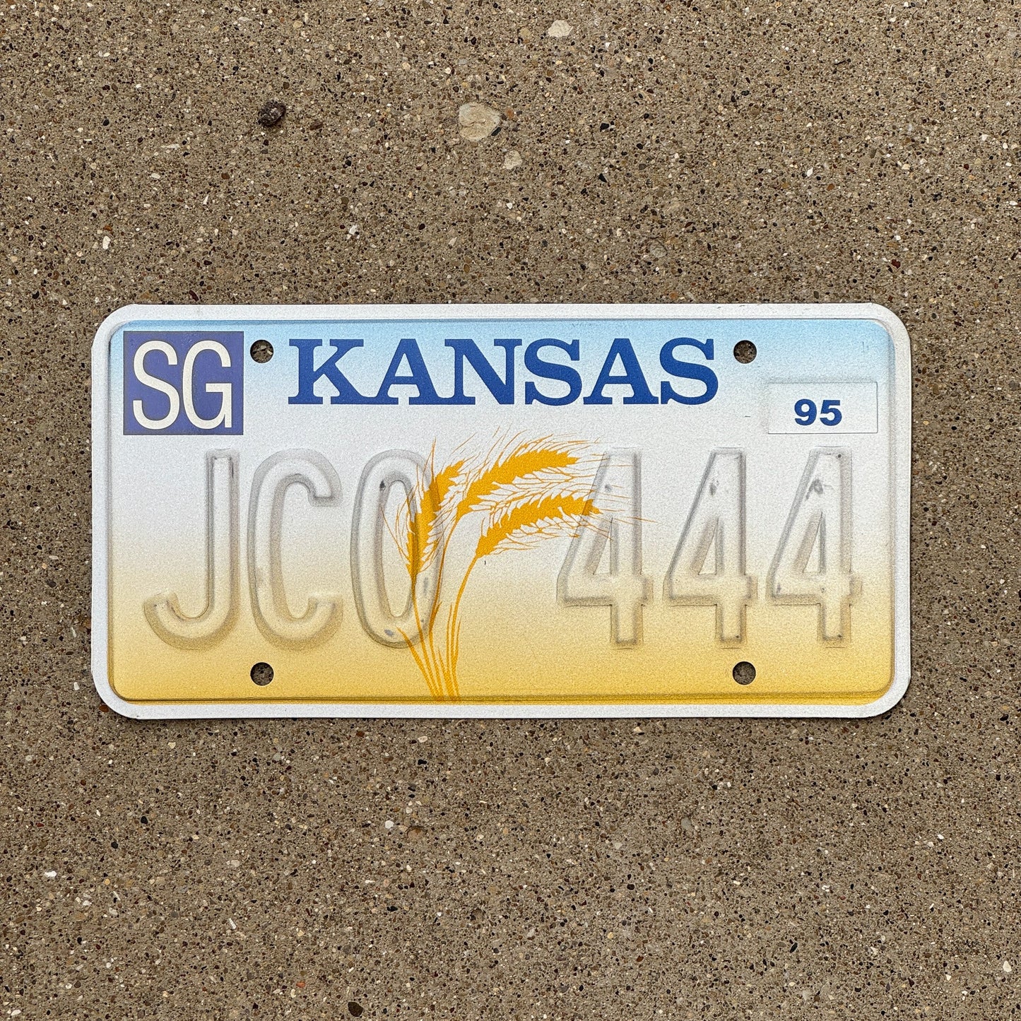 Photo of a 1995 Kansas Error License Plate Auto Tag Garage Decor Vintage Repeat Repeating Misprint JCO 444