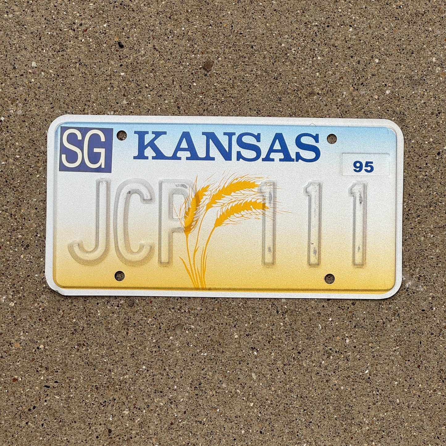 Photo of a 1995 Kansas Error License Plate Auto Tag Garage Decor Vintage Repeat Repeating Misprint JCP 111