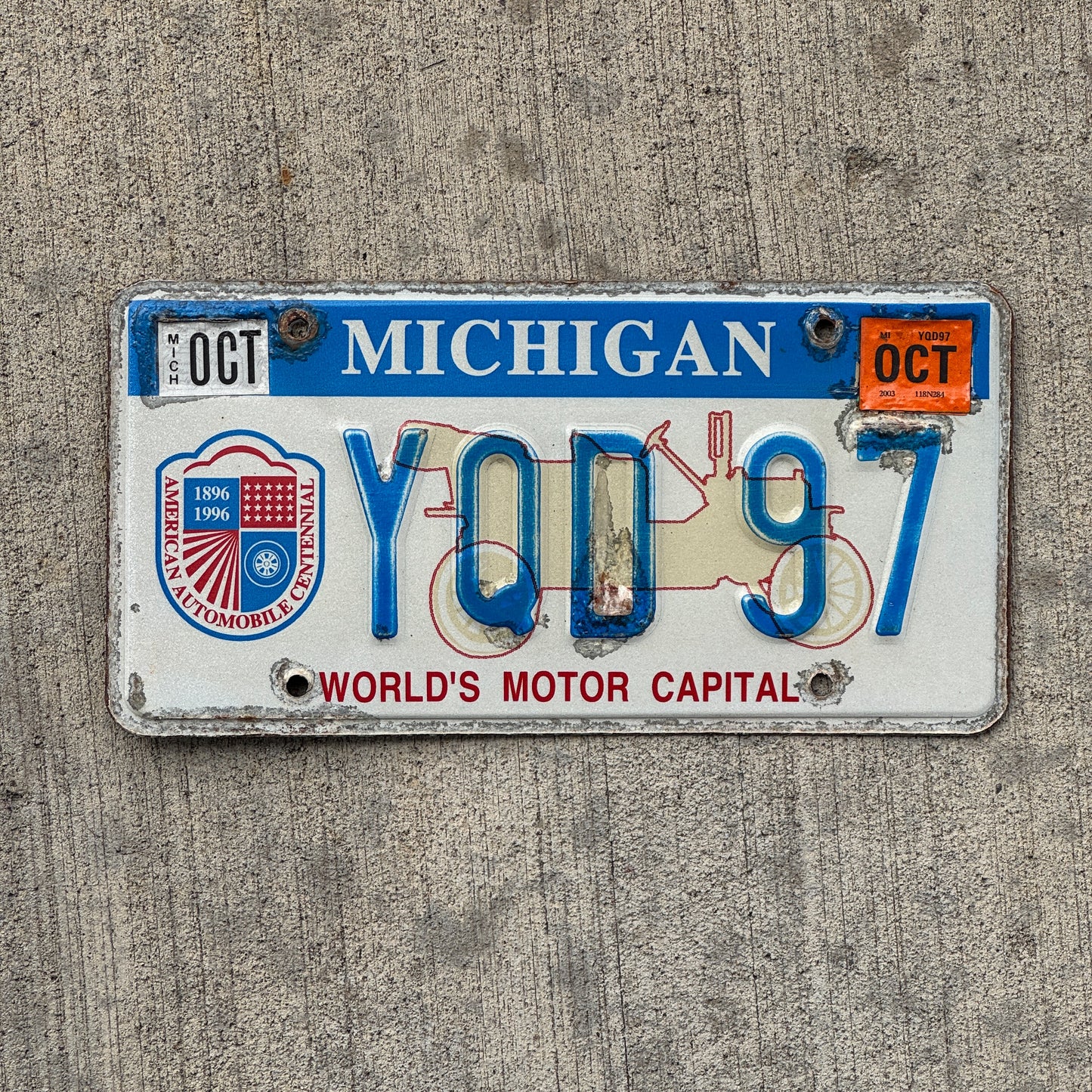 Photo of a 1996 2003 Michigan Graphic / Specialty License Plate Auto Tag Garage Decor Vintage World's Motor Capital YQD 97 with original patina