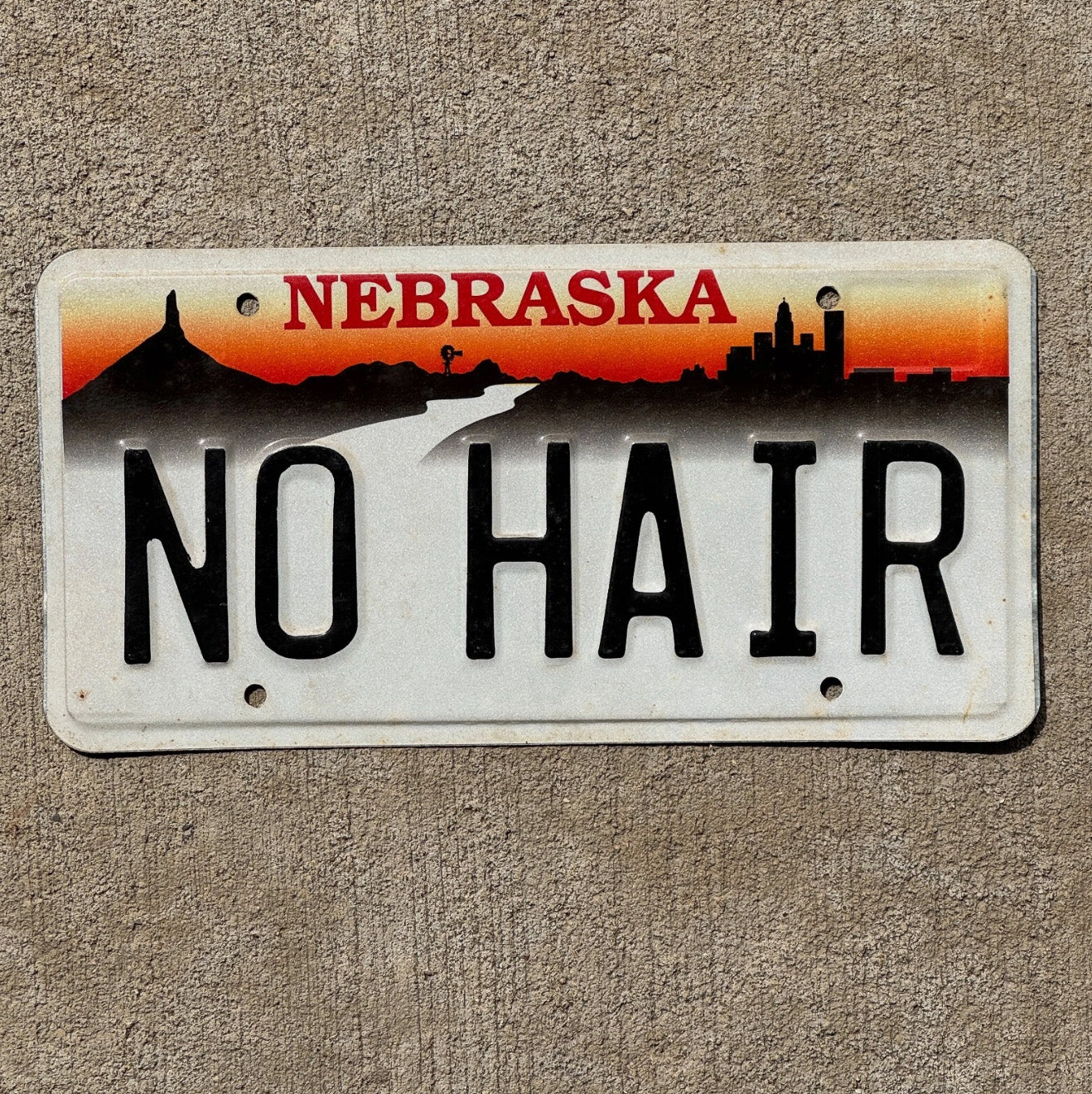 Photo of a 1996 Nebraska Vanity License Plate Auto Tag Garage Decor Vintage Bald Gift NO HAIR with original patina