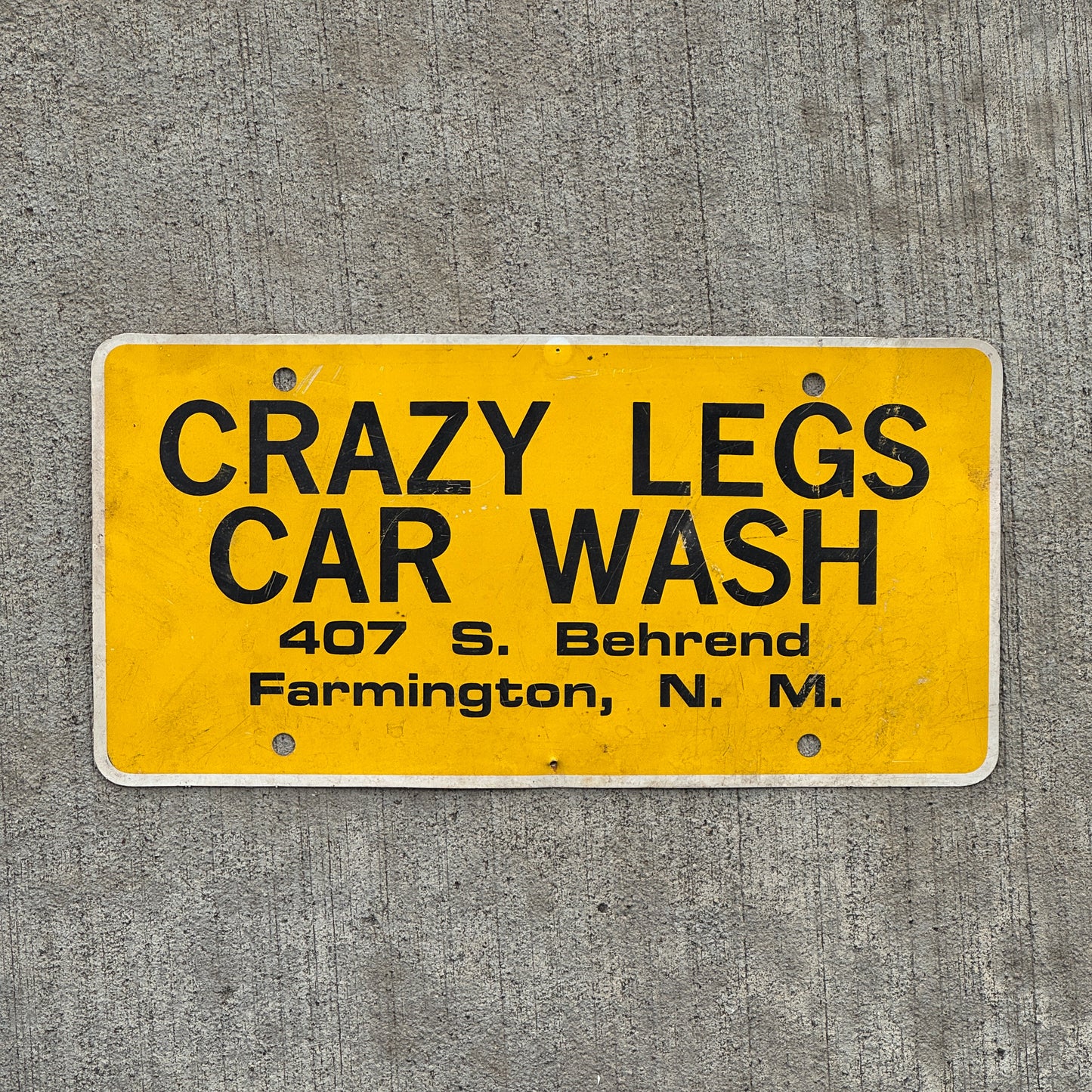 Photo of a 2000 Era Crazy Legs Car Wash Farmington New Mexico Booster License Plate Auto Tag Garage Decor Vintage Flimsy Plastic with original patina
