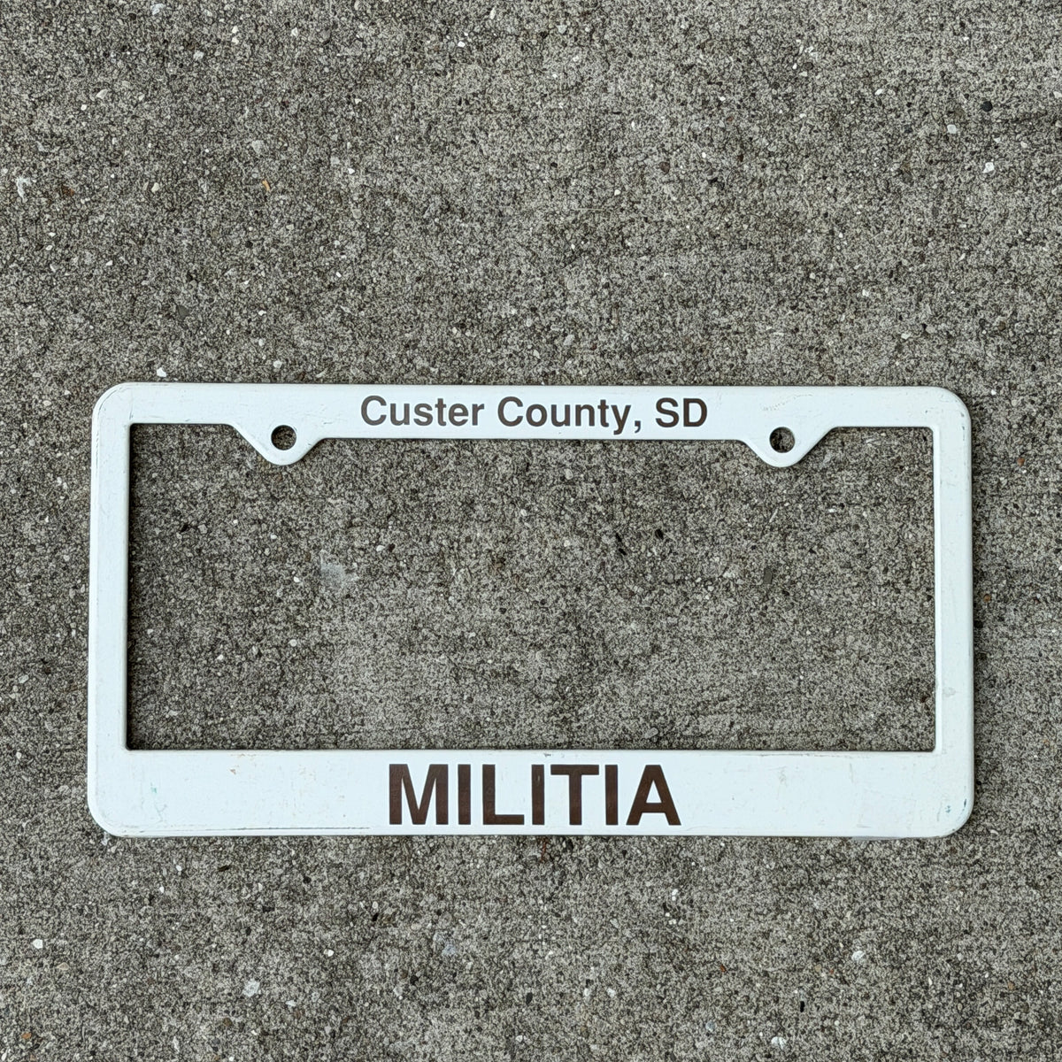 Photo of a 2000 Era Custer County South Dakota License Plate Frame Auto Tag 2 Vintage Garage
Militia Plastic with original patina