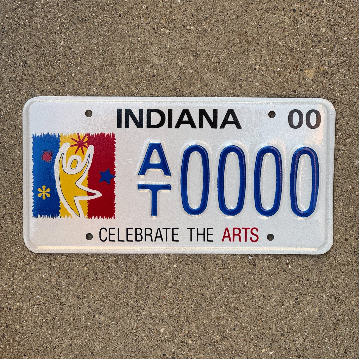 Photo of a 2000 Indiana Graphic Sample License Plate Auto Tag Garage Decor Vintage Clebrate Arts Trust AT 0000 with original patina