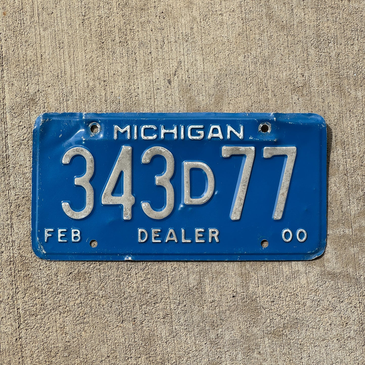 Photo of a 2000 Michigan Dealer License Plate Auto Tag Garage Decor Vintage 343 D 77 with original patina