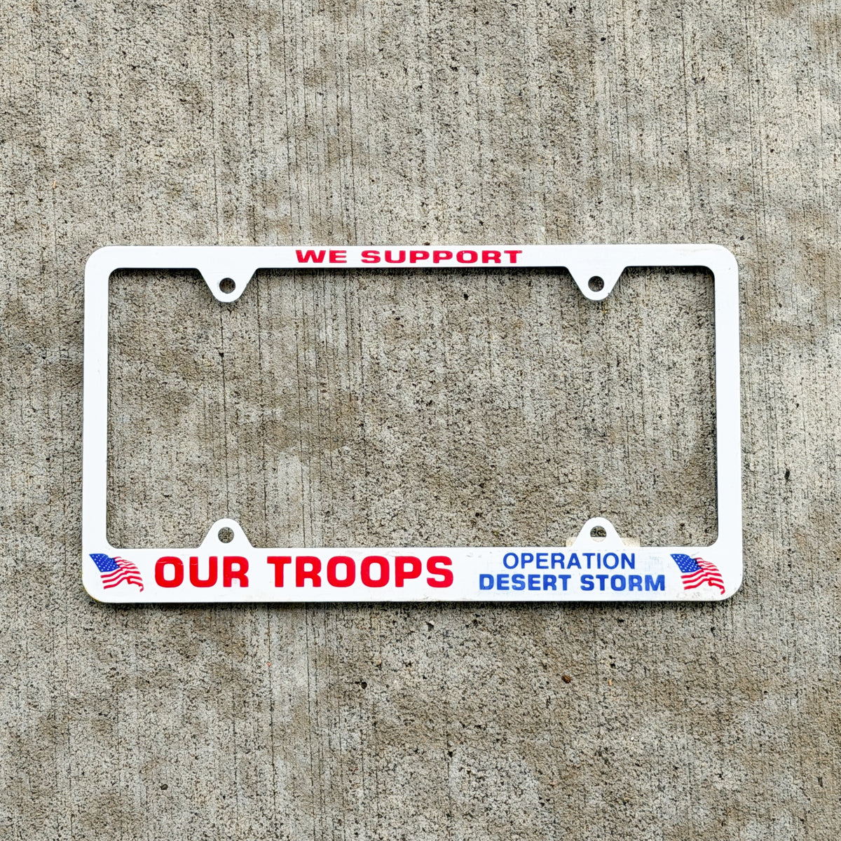 Photo of a 2001 Operation Desert Storm License Plate Frame Auto Tag Garage Decor Vintage Operation Desert Storm We Support Our Troops Plastic with original patina