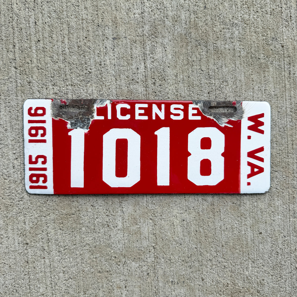 Photo of a 1915 1916 West Virginia Porcelain License Plate Auto Tag Garage Decor Vintage Low Number Four Digit 1018 with original patina