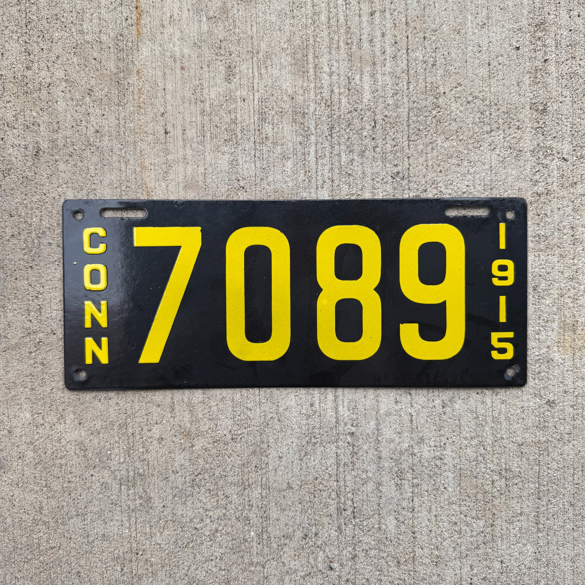 Photo of a 1915 Connecticut Porcelain License Plate Auto Tag Garage Decor Vintage Low Number Four Digit 7089 with original patina