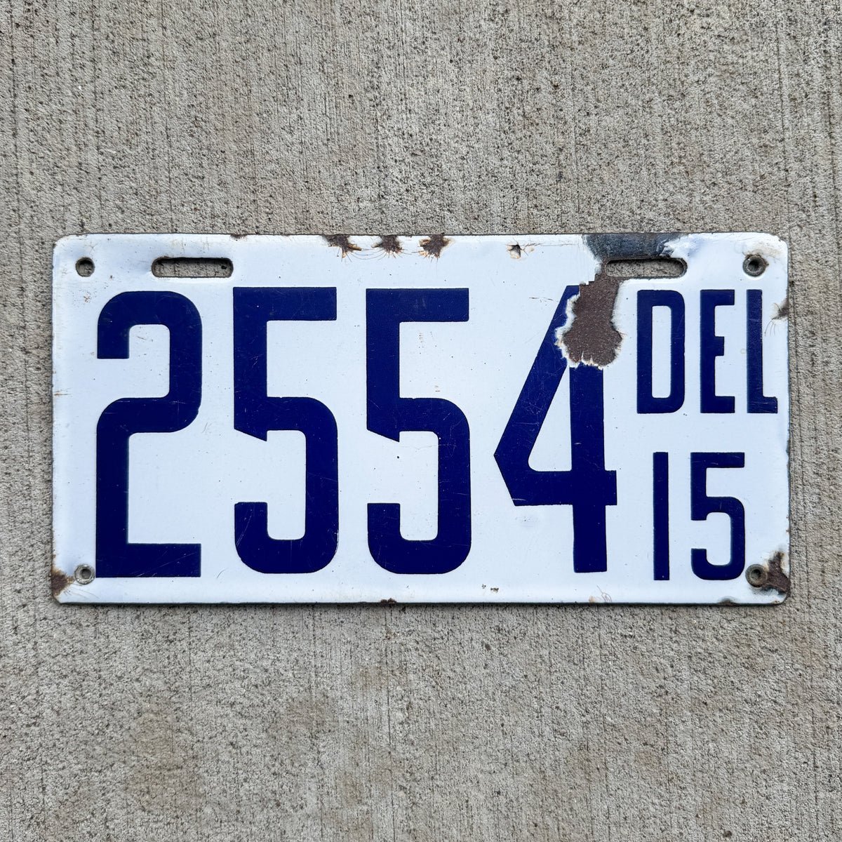 Photo of a 1915 Delaware Porcelain License Plate Auto Tag Garage Decor Vintage Low Number Four Digit 2554 with original patina