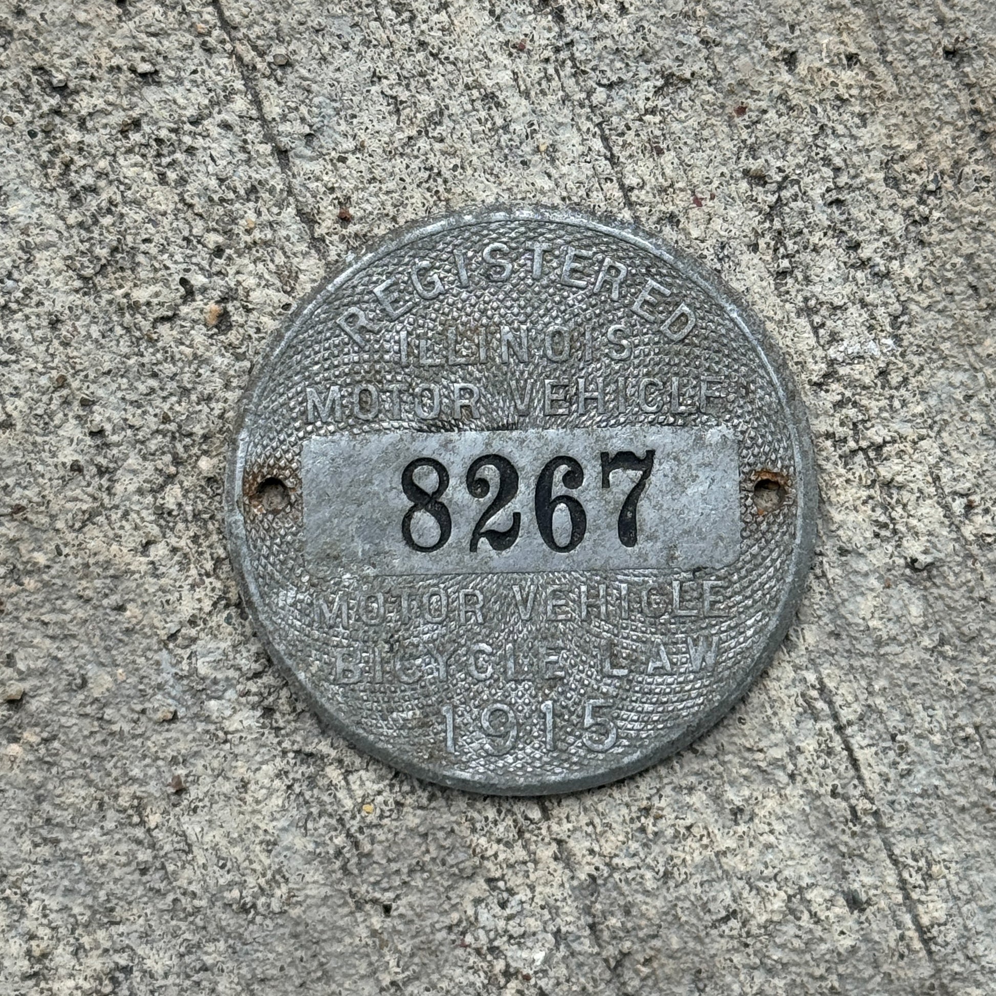 Photo of a 1915 Illinois Dashboard Disc Auto Tag Garage Decor Vintage Dash Disk Low Number Four Digit 8267 with original patina
