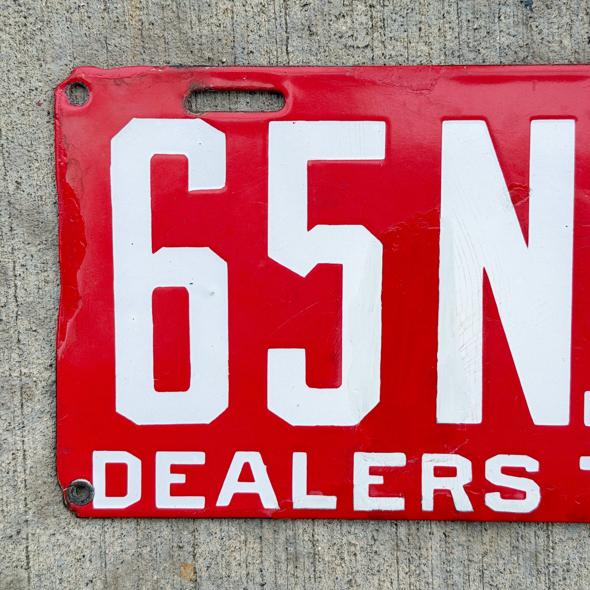 Photo of a 1915 New Brunswick Porcelain Dealer License Plate Auto Tag Garage Decor Vintage Low Number Two Digit 65 with original patina