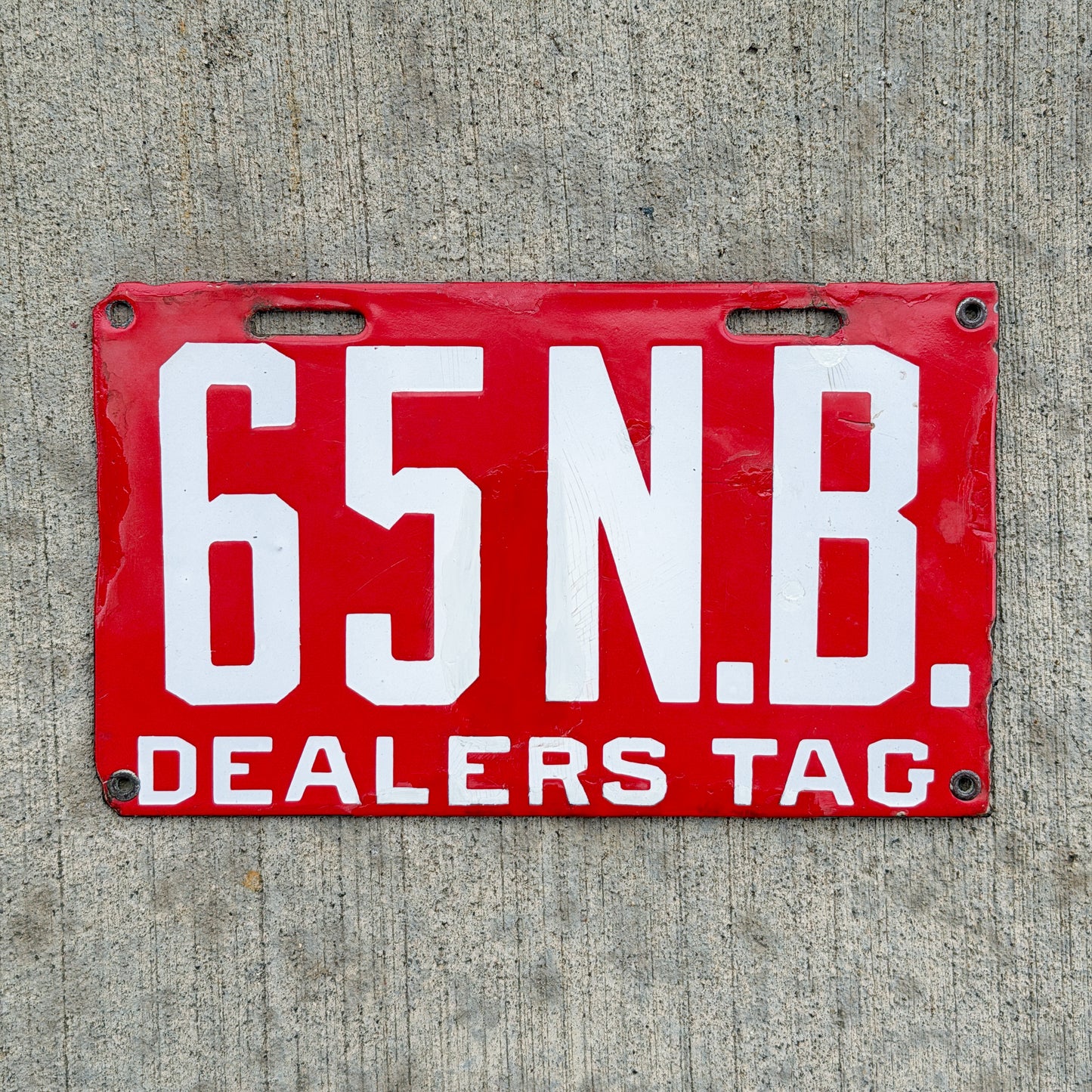 Photo of a 1915 New Brunswick Porcelain Dealer License Plate Auto Tag Garage Decor Vintage Low Number Two Digit 65 with original patina
