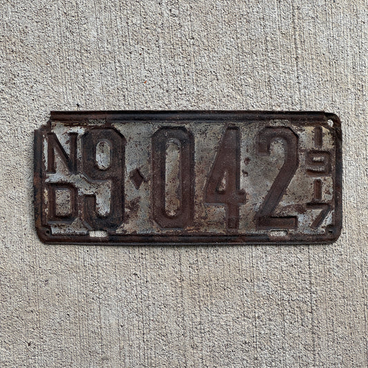 Photo of a 1917 North Dakota License Plate Auto Tag Garage Decor Vintage Four Digit Low Number 9042 with original patina