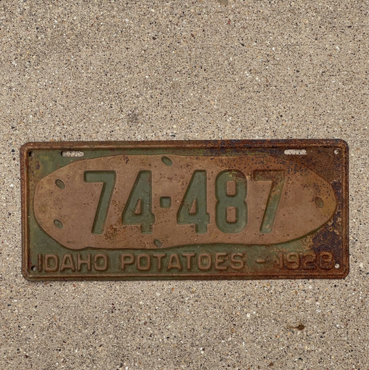 1928 Idaho potato license plate with numbers 74-487 on a concrete surface