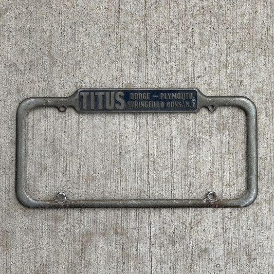 Photo of a 1940 Era Titus Springfield Gardens New York License Plate Frame Auto Tag Garage Decor Vintage Dodge Plymouth Dealer with original patina