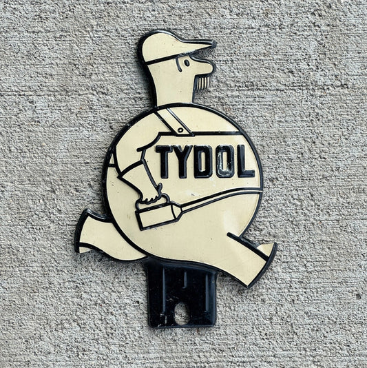 Photo of a 1940 Era Tydol License Plate Topper Auto Tag Garage Decor Vintage White Running Man Veedol Gas Oil Collectible with original patina