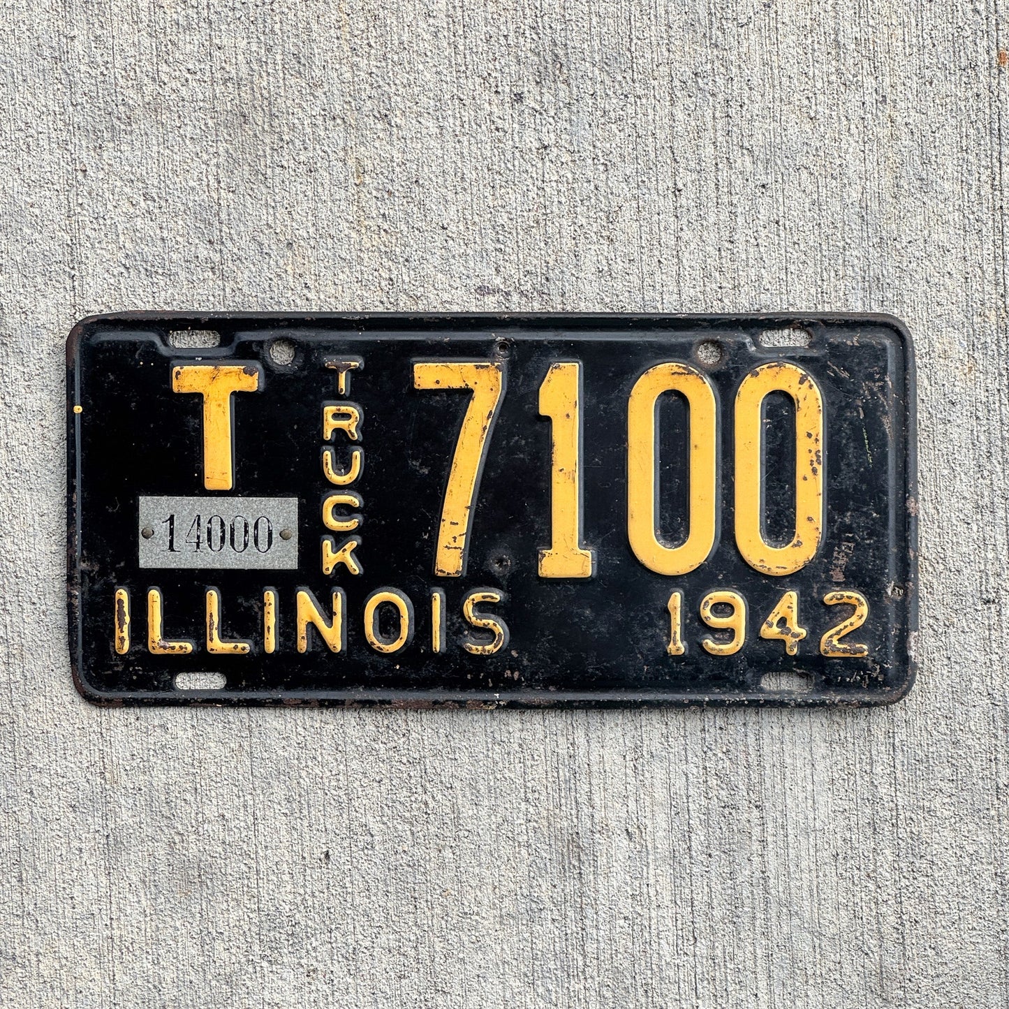 Photo of a 1942 Illinois Truck Mileage Tax License Plate Auto Tag Garage Decor Vintage 14000 LBS T 7100 with original patina