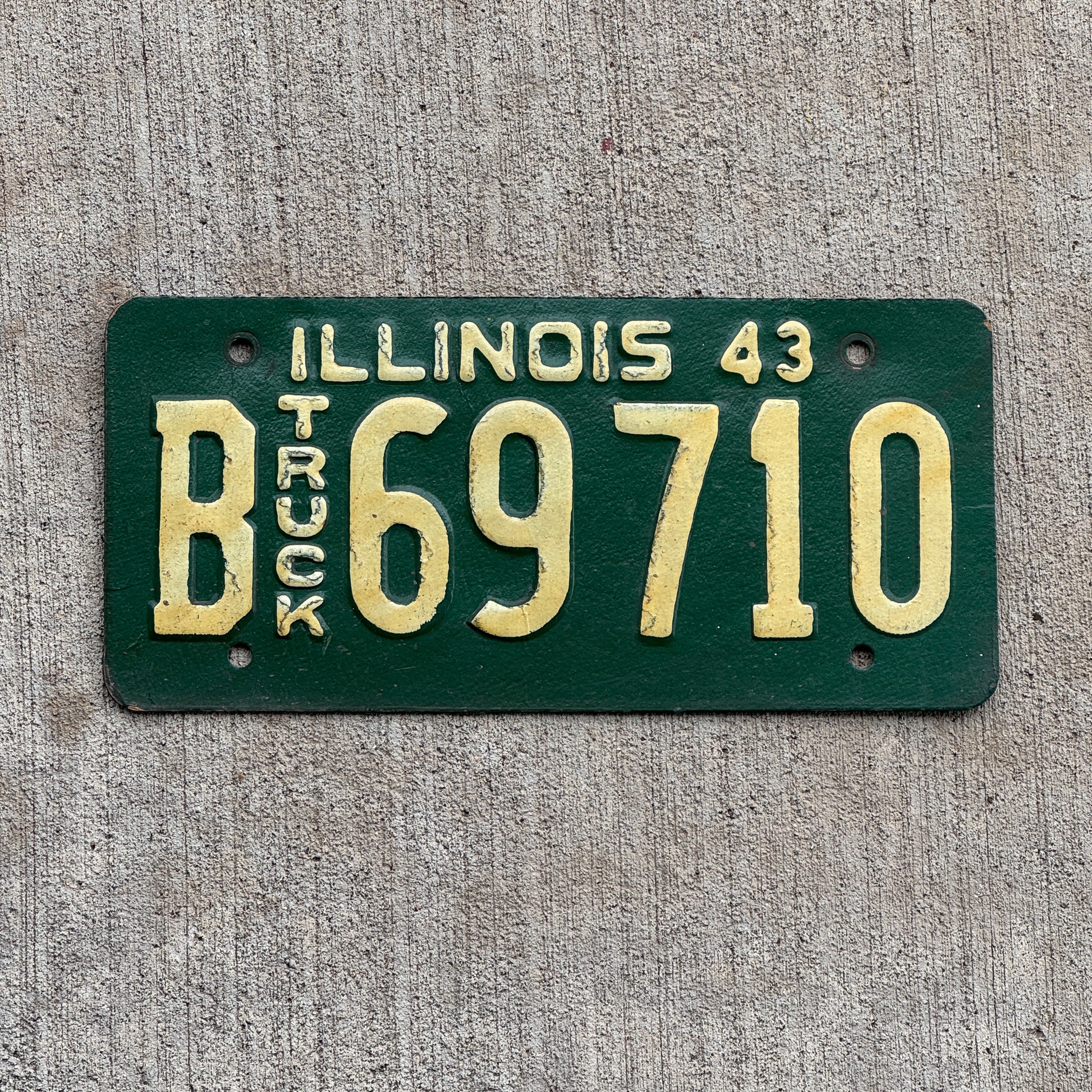 Photo of a 1943 Illinois Truck License Plate Auto Tag Garage Decor Vintage Embossed Text B 69710 with original patina