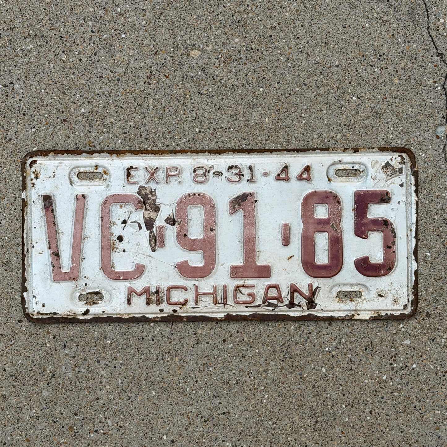 Photo of a 1944 Michigan License Plate Auto Tag Garage Decor Vintage Half Year VC 91 85 with original patina