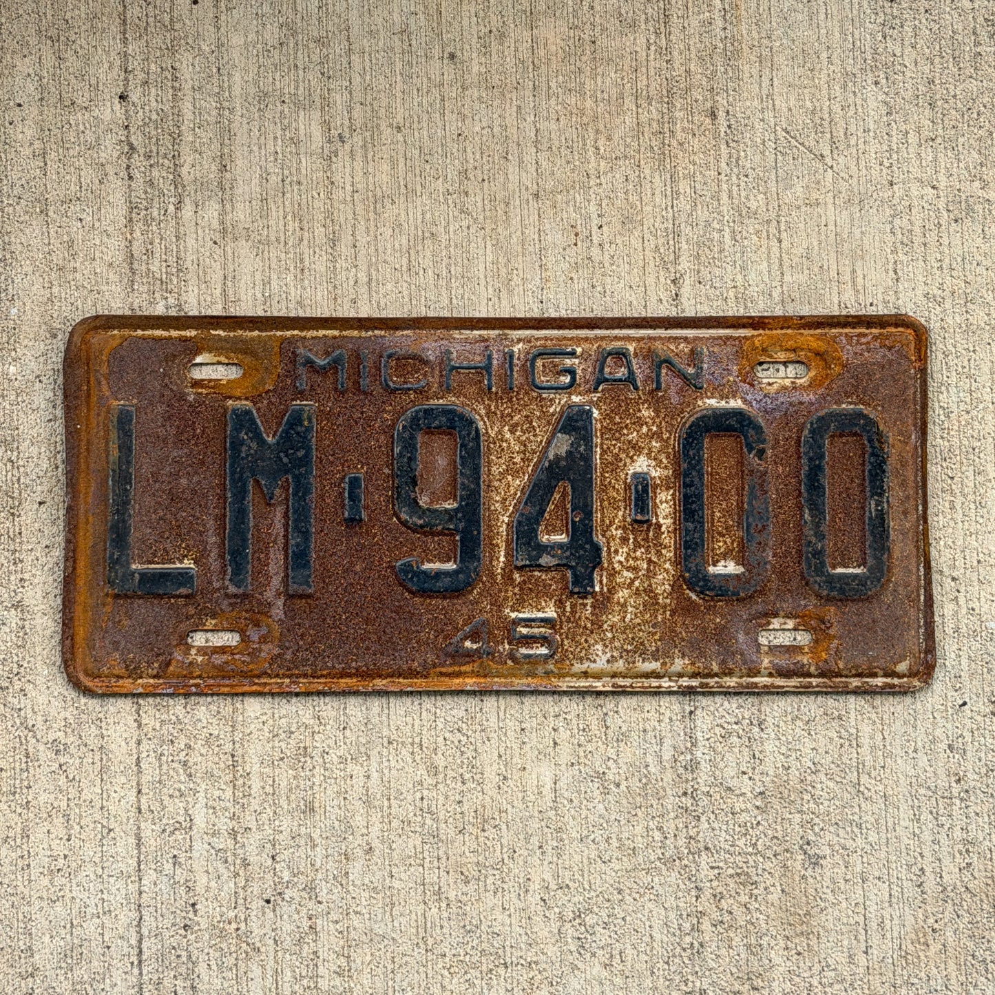 Photo of a 1945 Michigan License Plate Auto Tag Garage Decor Vintage LM 94 00 with original patina