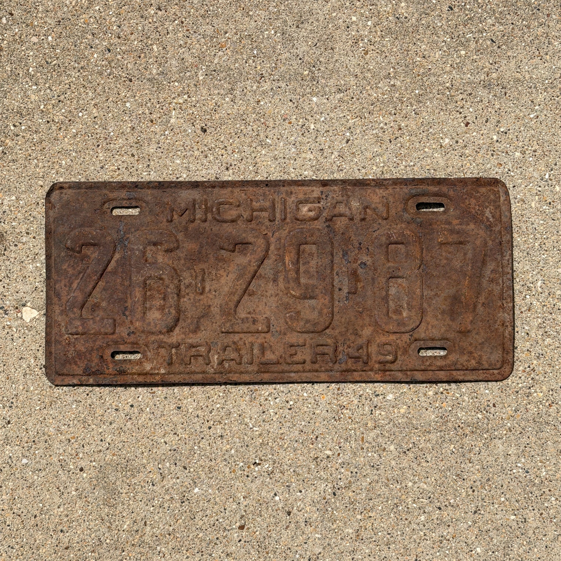 Photo of a 1949 Michigan Trailer License Plate Auto Tag Garage Decor Vintage 26 29 87 with original patina