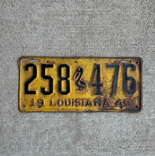 Vintage Louisiana license plate with iconic pelican graphic and the number 258 476 on a concrete background.