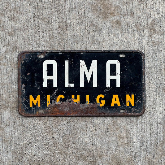 Photo of a 1950 Era Alma Michigan Booster License Plate Auto Tag Garage Decor Vintage Metal with original patina