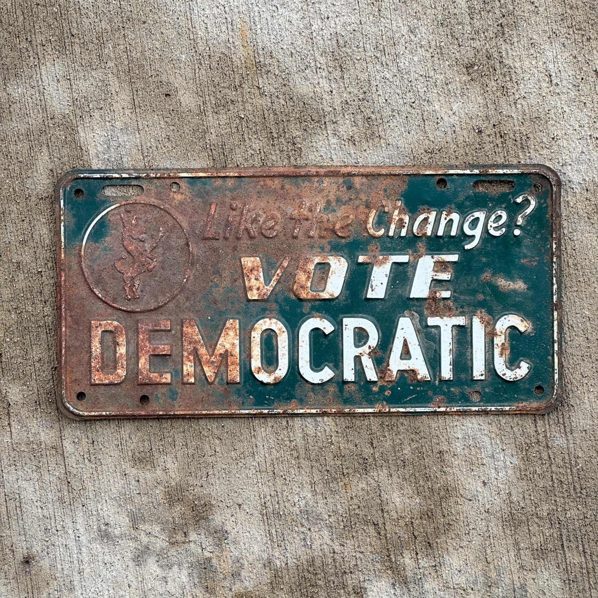 Photo of a 1950 Era Booster License Plate Auto Tag Garage Decor Vintage Democrat Politics Political Like the Change? Vote Democratic with original patina