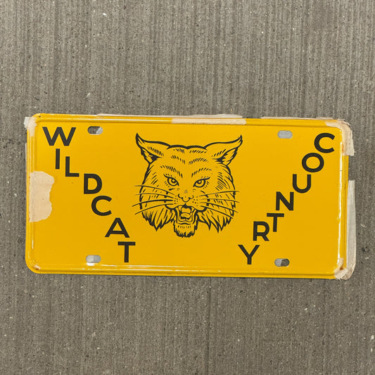 Photo of a 1950 Era Booster License Plate Auto Tag Garage Decor Vintage New Old Stock with Rice Paper Wildcat Country with original patina