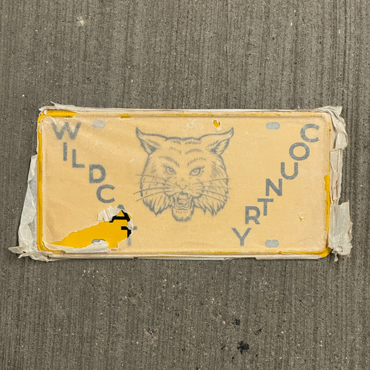 Photo of a 1950 Era Booster License Plate Auto Tag Garage Decor Vintage New Old Stock with Rice Paper Wildcat Country with original patina