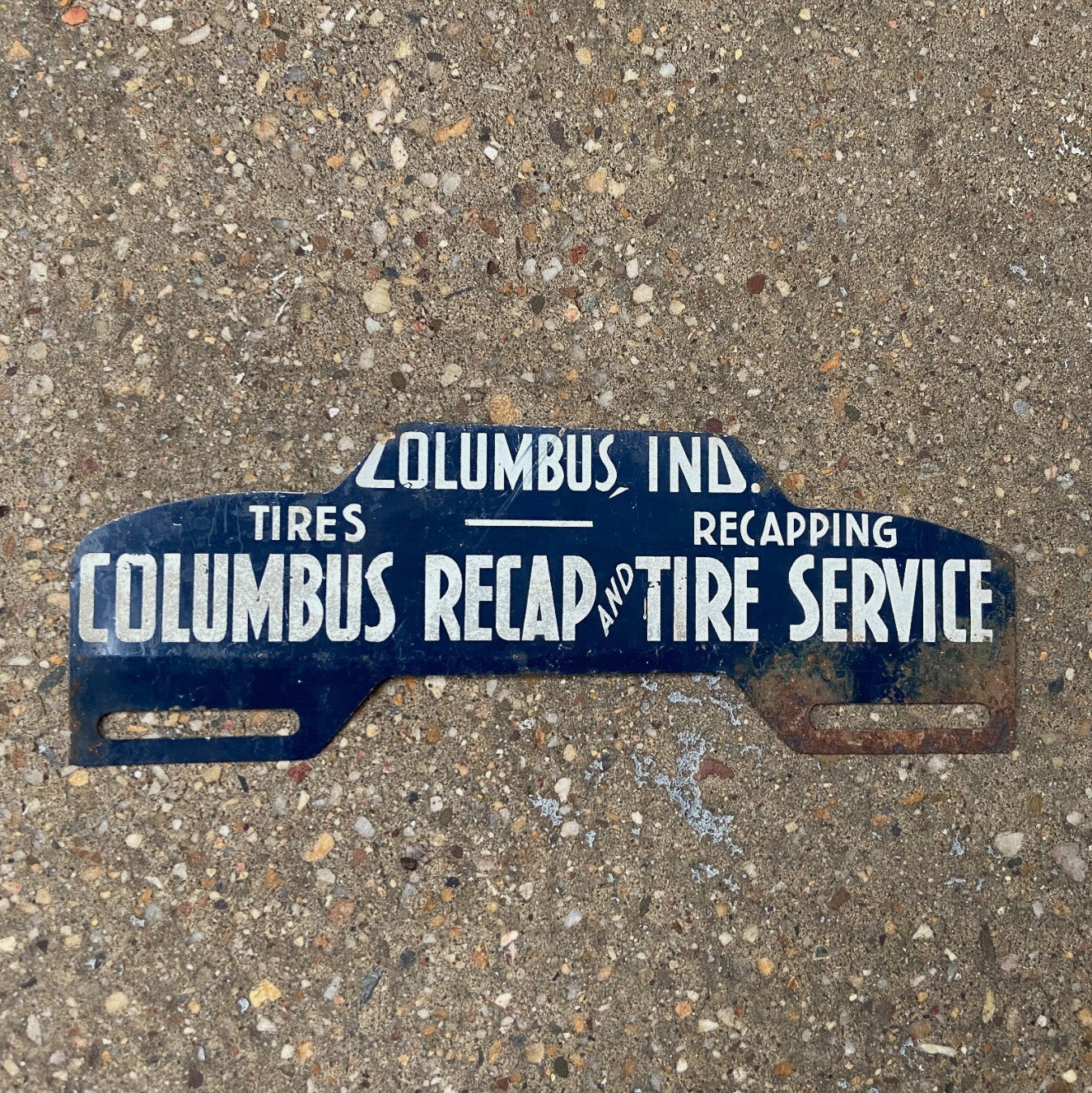 Photo of a 1950 Era Columbus Indiana License Plate Topper Auto Tag Garage Decor Vintage Recap and Tire Service Car Auto with original patina