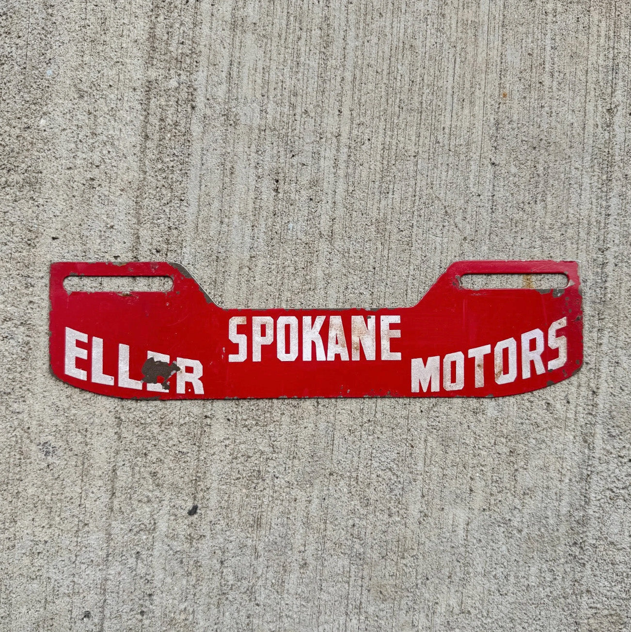 Photo of a 1950 Era Eller Motors Spokane Washington License Plate Topper Auto Tag Garage Decor Vintage Auto Dealer Garage with original patina