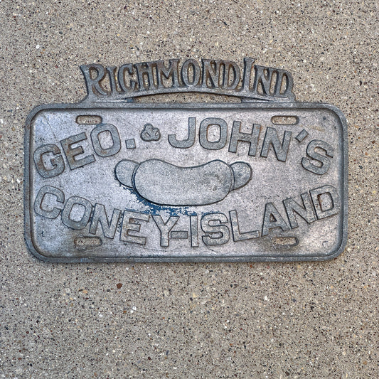Photo of a 1950 Era Geo and John's Coney Island Richmond Indiana Booster License Plate Auto Tag Garage Decor Vintage Hot Dog Chain Cast Aluminum with original patina
