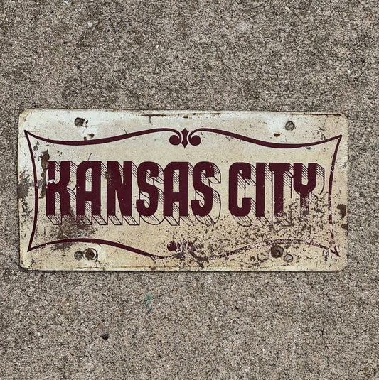 Photo of a 1950 Era Kansas City Missouri Booster License Plate Auto Tag Garage Decor Vintage Maroon Red White with original patina