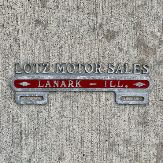 Photo of a 1950 Era Lotz Motor Sales Lanark Illinois License Plate Topper Auto Tag Garage Decor Vintage Cast Aluminum Buick Pontiac with original patina