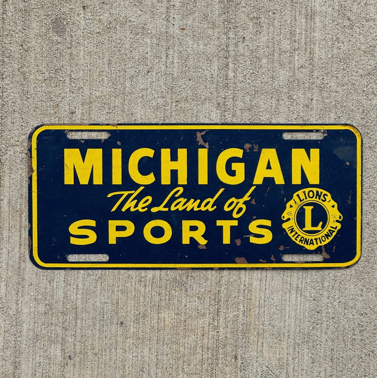 Photo of a 1950 Era Michigan Booster License Plate Auto Tag Garage Decor Vintage Land of Sports Lions Club with original patina