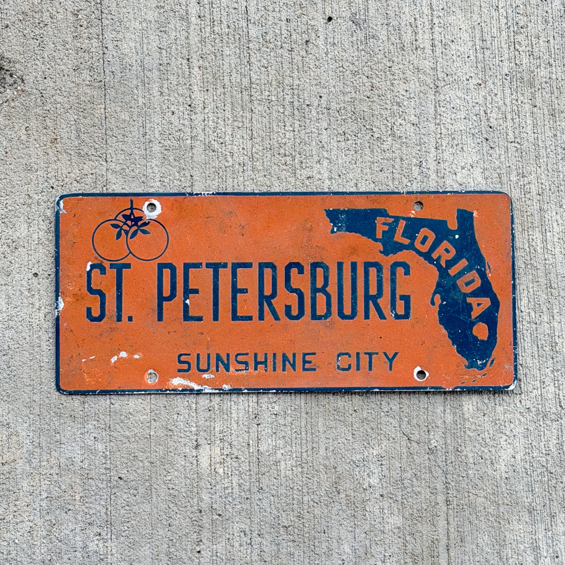 Photo of a 1950 Era St Petersburg Florida Booster License Plate Vintage Auto Tag Garage Tampa Bay FL Oranges Smaltz Paint with original patina