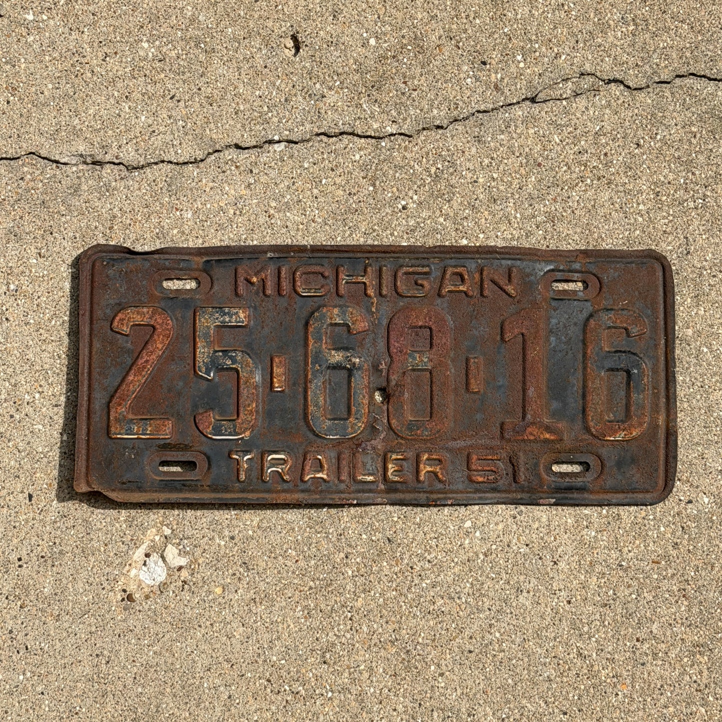 Photo of a 1951 Michigan Trailer License Plate Auto Tag Garage Decor Vintage 25 68 16 with original patina