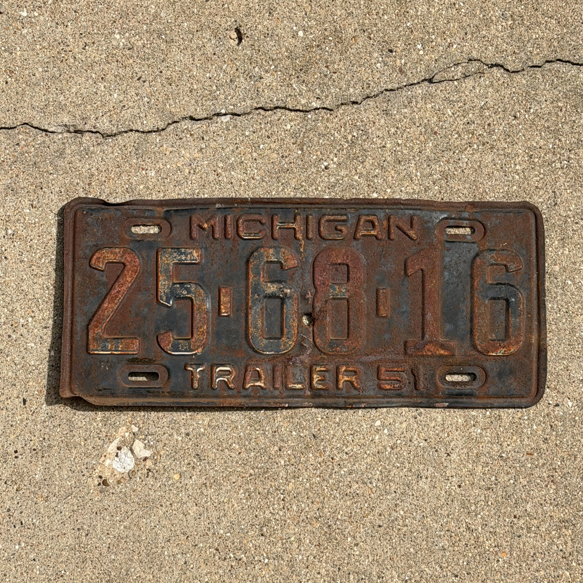 Photo of a 1951 Michigan Trailer License Plate Auto Tag Garage Decor Vintage 25 68 16 with original patina