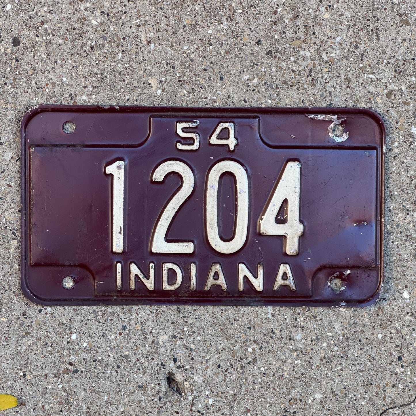 Photo of a 1954 Indiana Motorcycle License Plate Auto Tag Garage Decor Vintage Low Number Four Digit 1204 with original patina