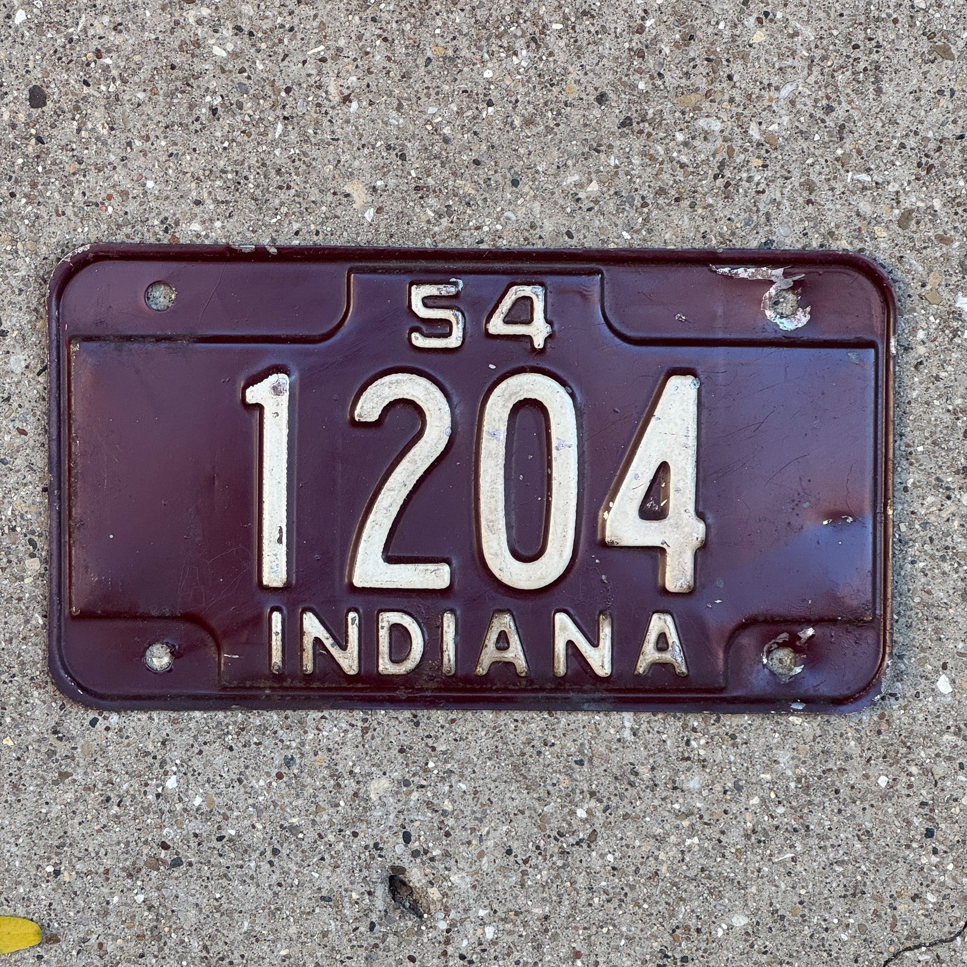 Photo of a 1954 Indiana Motorcycle License Plate Auto Tag Garage Decor Vintage Low Number Four Digit 1204 with original patina