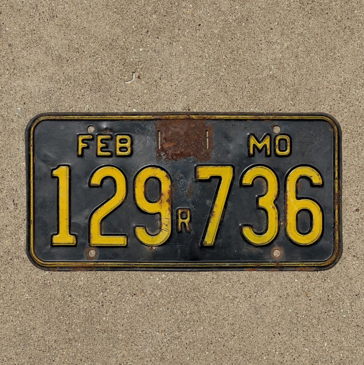 Image of a 1956 Missouri License Plate on a concrete background.
