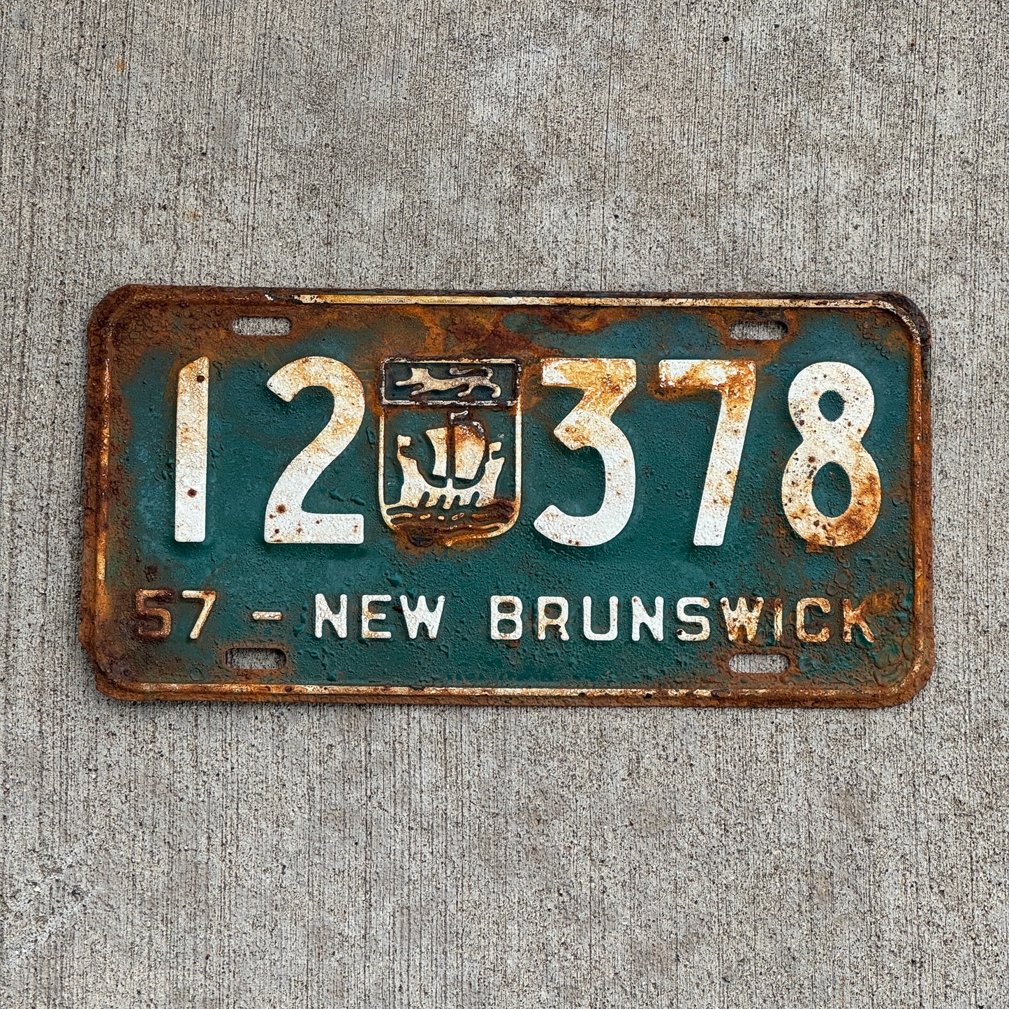 Photo of a 1957 New Brunswick License Plate Auto Tag 2 Vintage Garage Provincial Coat of Arms 12 378 with original patina