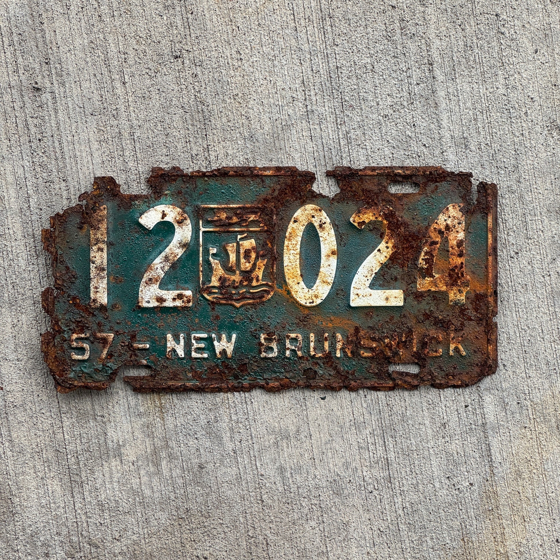 Photo of a 1957 New Brunswick License Plate Auto Tag Garage Decor Vintage Provincial Coat of Arms 12 024 with original patina