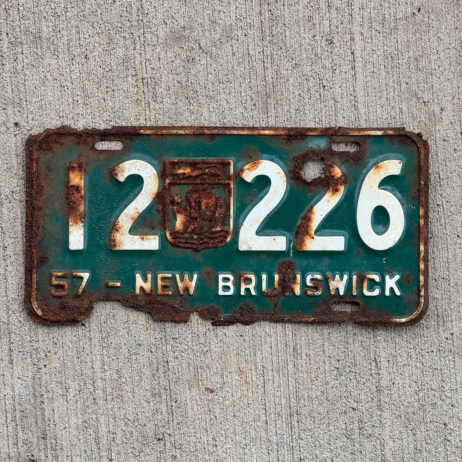 Photo of a 1957 New Brunswick License Plate Auto Tag Garage Decor Vintage Provincial Coat of Arms 12 226 with original patina